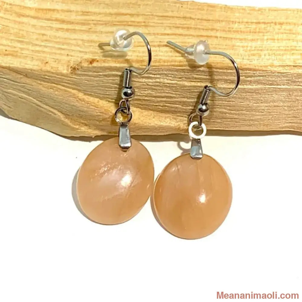 Paire de boucles d'oreilles en pierre naturelle Pierre de Lune Pêche, acier inoxydable argenté, posées sur un bâton de Palo Santo