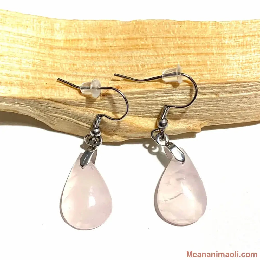 Paire de boucles d'oreilles pendantes élégantes en acier inoxydable argenté avec pierre naturelle Quartz Rose, posées sur un bâton de Palo Santo
