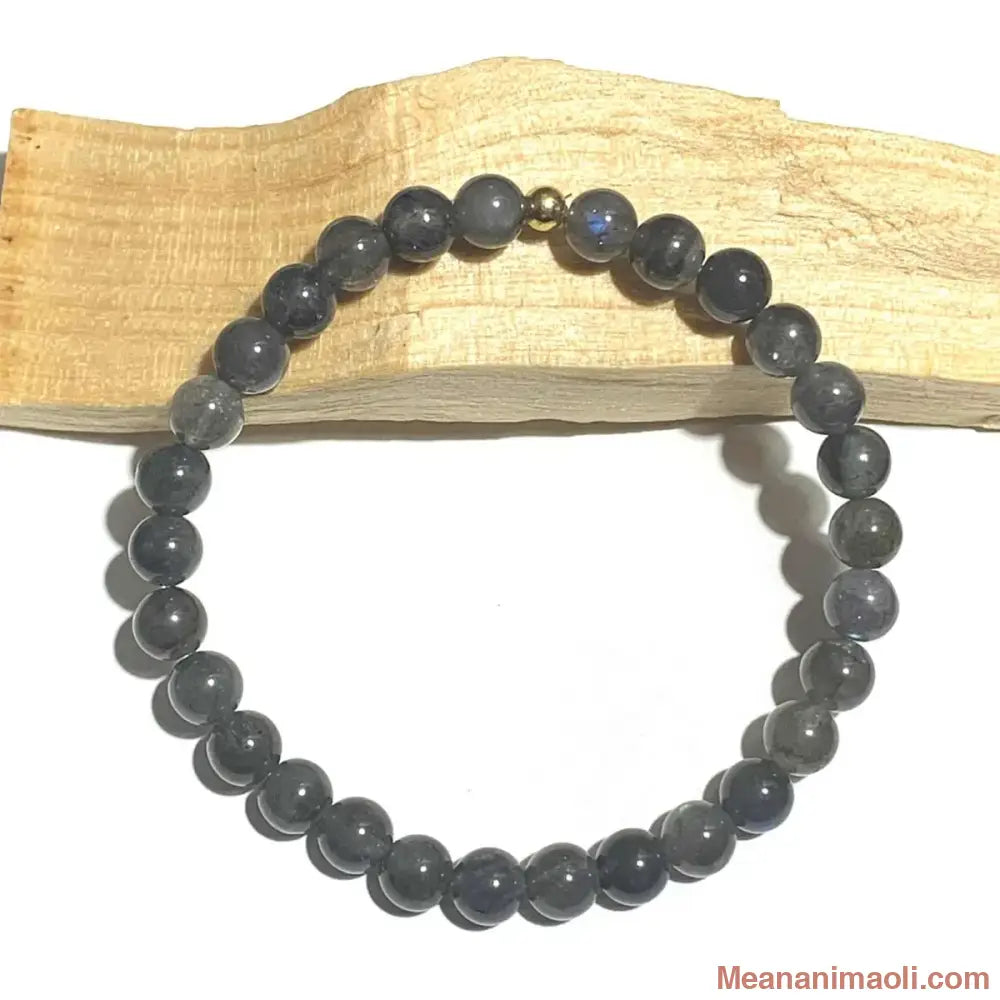 Bracelet pierre naturelle en Labradorite 6mm, perle acier inoxydable doré posé sur un bâton de palo santo.