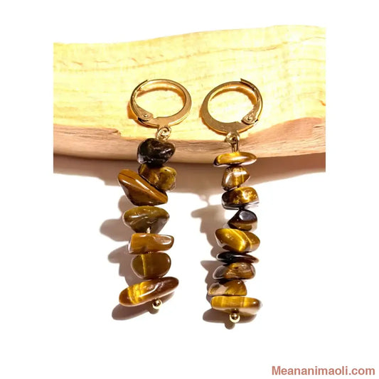 Boucles d'oreilles pendantes en acier inoxydable doré avec perles chips d'Oeil de Tigre naturel posées sur un morceau de bois Palo Santo, une création MEANANIMAOLI