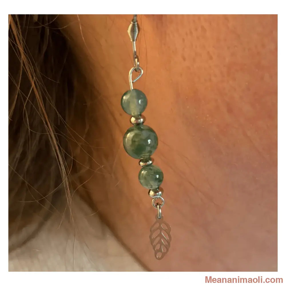 Gros plan d'une boucle d'oreille pendante en Agate Mousse (perles 6mm et 8mm) portée à l'oreille avec sa breloque feuille en acier inoxydable