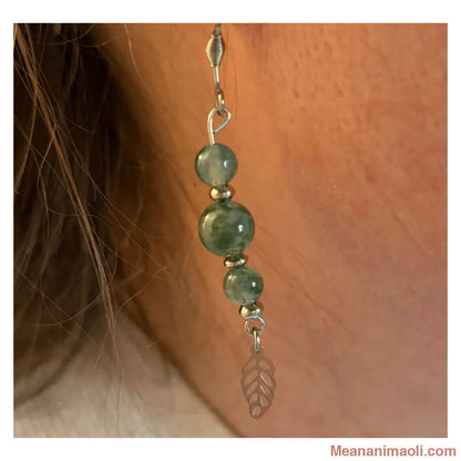 Gros plan d'une boucle d'oreille pendante en Agate Mousse (perles 6mm et 8mm) portée à l'oreille avec sa breloque feuille en acier inoxydable