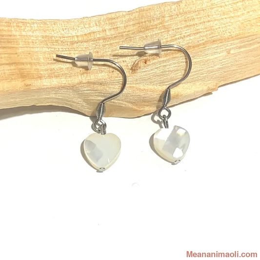 Paire de boucles d'oreilles en Nacre en forme de Cœur, acier inoxydable argenté, posées sur un bâton de Palo Santo