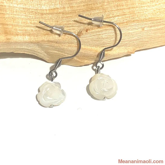 Paire de boucles d'oreilles en Nacre en forme de Fleur, acier inoxydable argenté, posées sur un bâton de Palo Santo