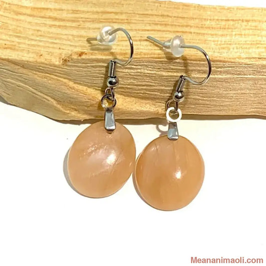 Paire de boucles d'oreilles en pierre naturelle Pierre de Lune Pêche, acier inoxydable argenté, posées sur un bâton de Palo Santo