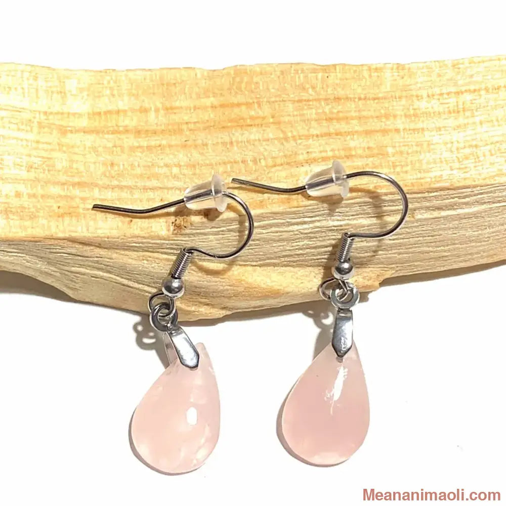 Paire de boucles d'oreilles pendantes en acier inoxydable argenté avec pierre naturelle Quartz Rose, posées sur un bâton de Palo Santo