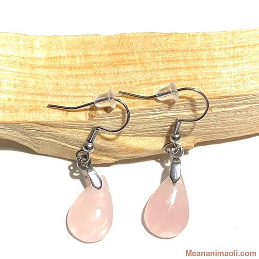 Paire de boucles d'oreilles pendantes en acier inoxydable argenté avec pierre naturelle Quartz Rose, posées sur un bâton de Palo Santo