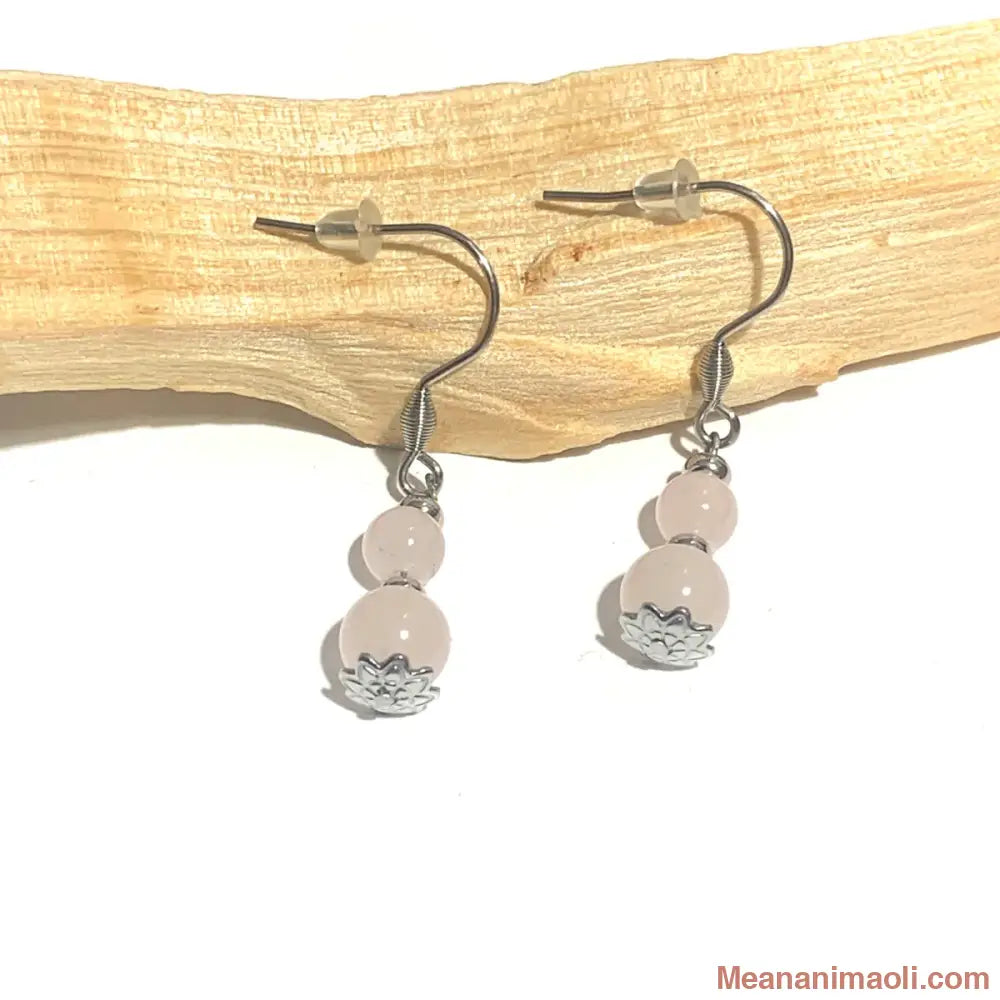 Paire de boucles d'oreilles en pierre naturelle Quartz Rose avec coupelles fleur sur acier inoxydable argenté, posées sur un bâton de Palo Santo