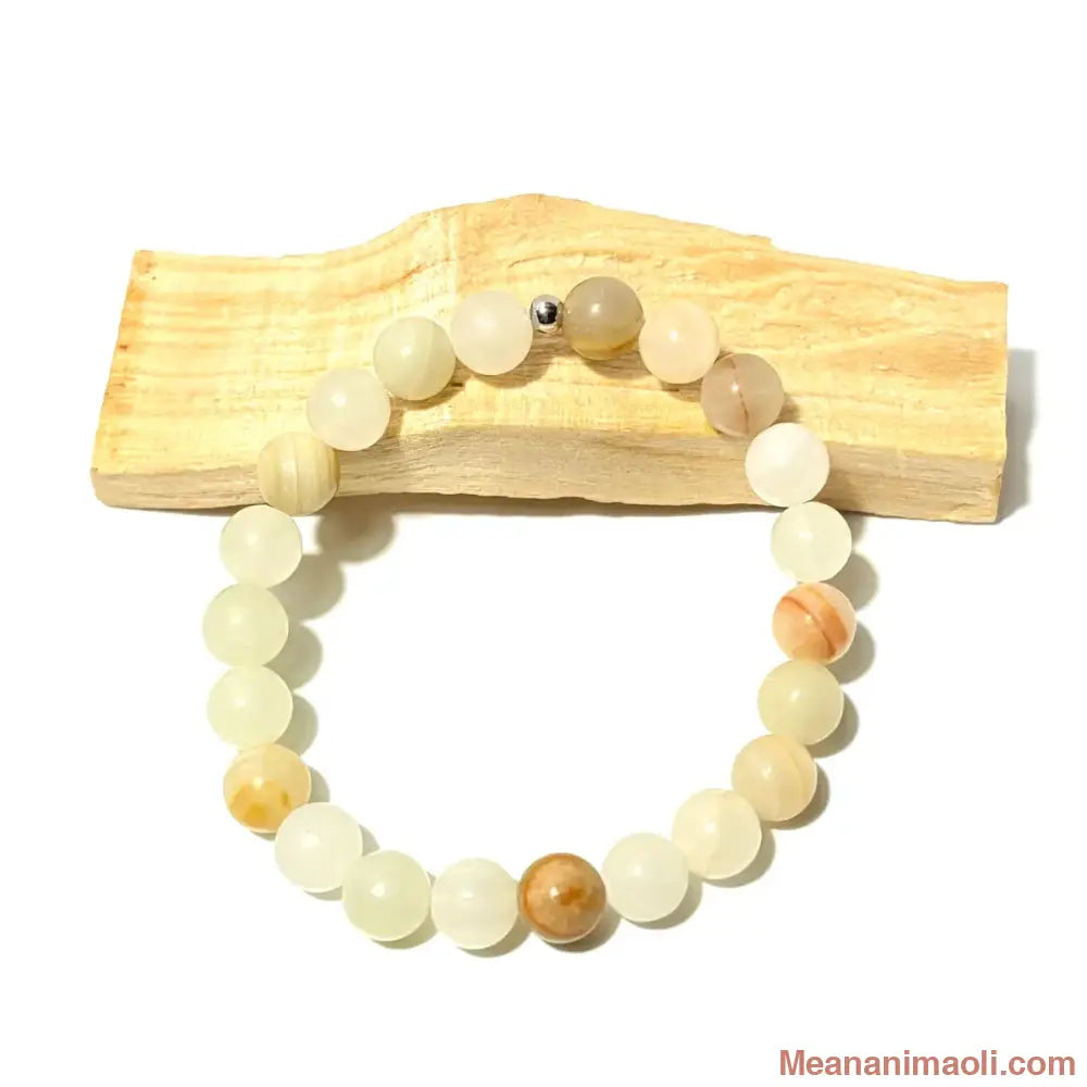 Bracelet en perles de 8 mm Aragonite naturelle posé sur un bois palo santo