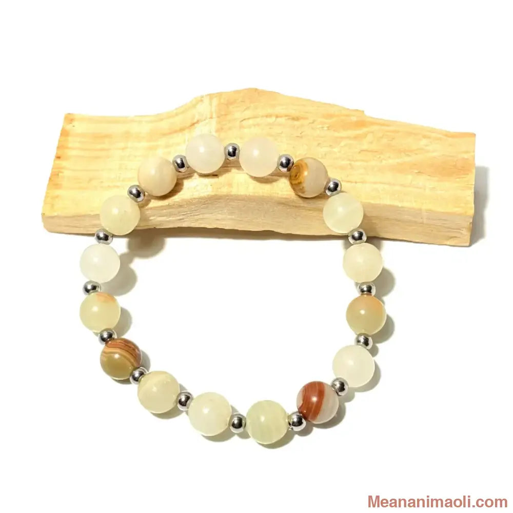 Bracelet en perles de 8 mm Aragonite naturelle et perles acier inoxydable argenté posé sur un bois palo santo