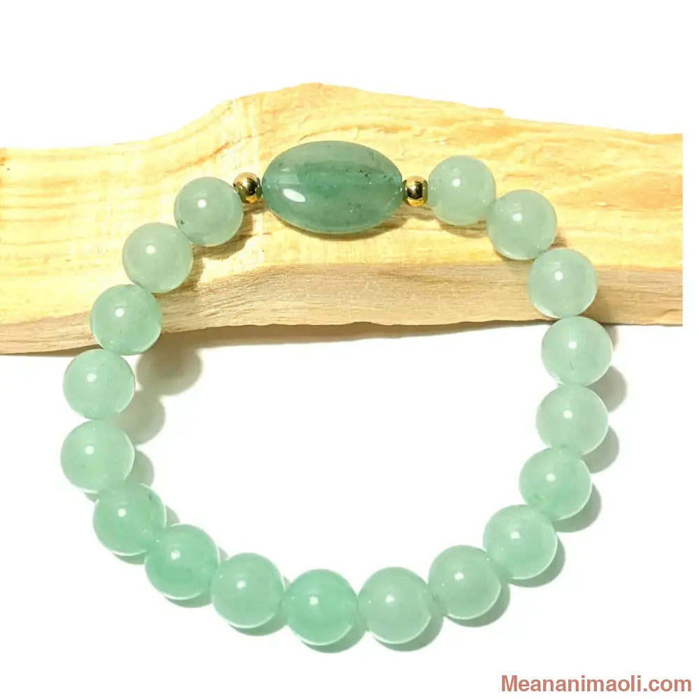 Bracelet de lithothérapie en perles d'Aventurine Verte de 8 mm avec perle centrale ovale, posé sur du bois de Palo Santo, boutique MEANANIMAOLI.