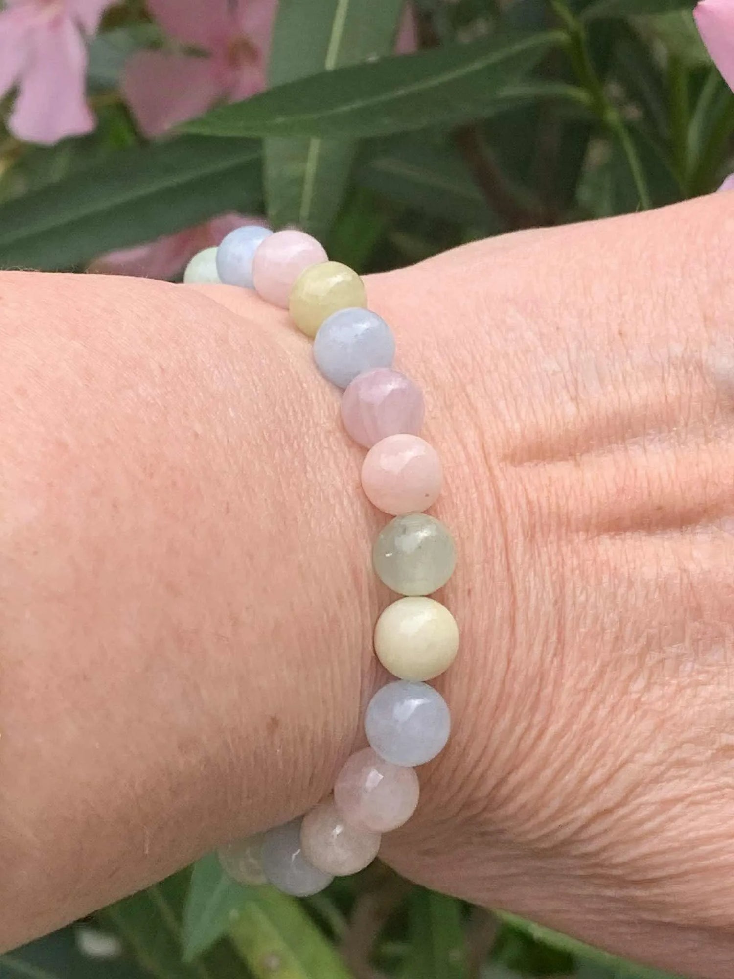 Gros plan sur le bracelet en perles de Béryl aux couleurs pastel