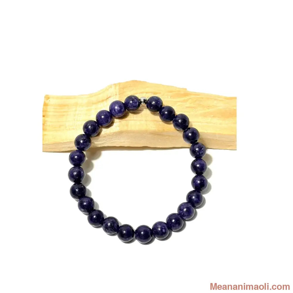 Bracelet en perles 8 mm rondes de Charoïte violet foncé avec une perle centrale en acier inoxydable argenté posé sur du bois de Palo Santo - MEANANIMAOLI