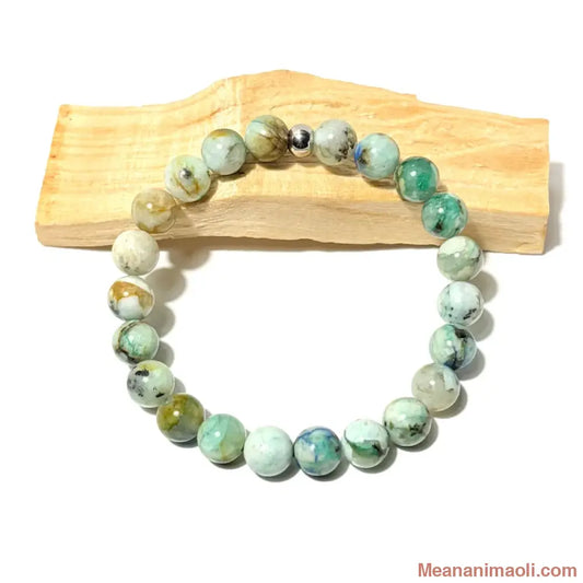 Bracelet en perles de 8 mm Chrysocolle naturelle posé sur un bois palo santo