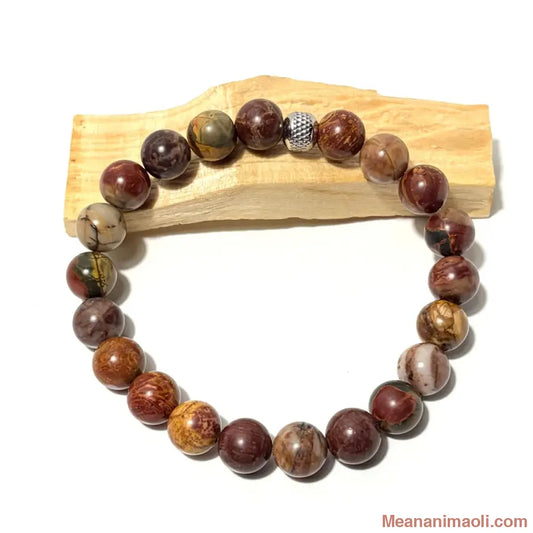 Bracelet en perles de 10 mm Jaspe Polychrome naturelposé sur un bois palo santo