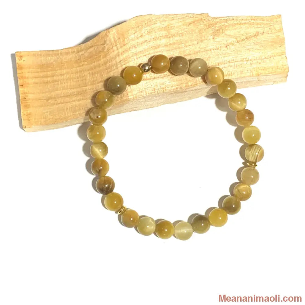 Bracelet pierre naturelle en Œil de Tigre 6mm, perles acier inoxydable doré posé sur u bâton de palo santo.