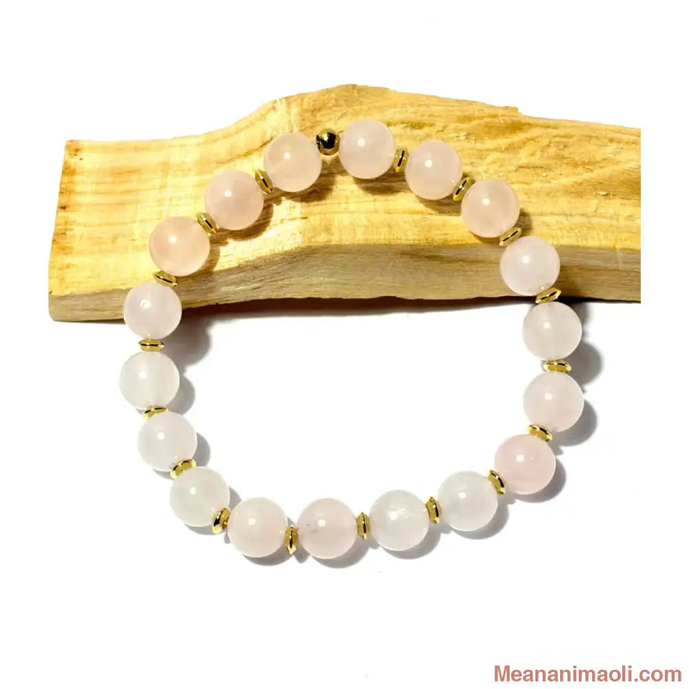 Bracelet en perles 8mm de Quartz Rose naturel avec séparateurs en acier inoxydable doré posé sur un morceau de bois Palo Santo, une création MEANANIMAOLI.