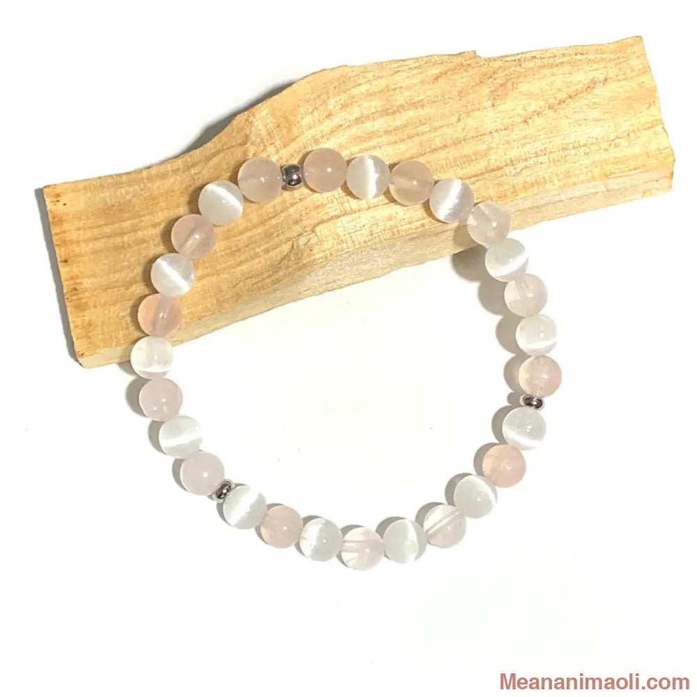 Bracelet en Quartz Rose et Sélénite 6mm, perle acier inoxydable argenté posé sur un bâton de palo santo.