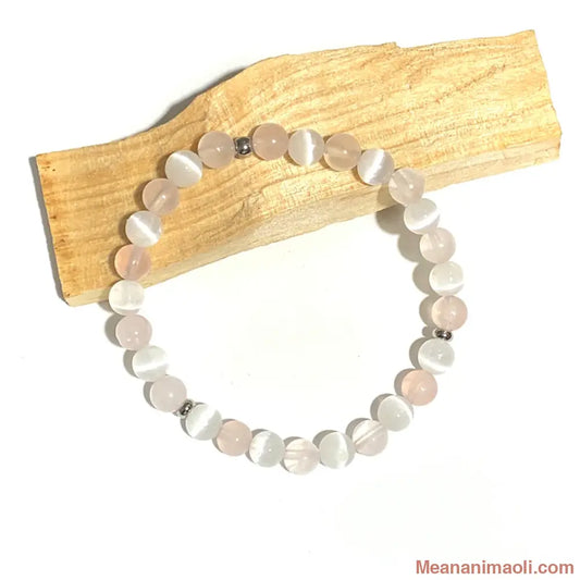 Bracelet en Quartz Rose et Sélénite 6mm, perle acier inoxydable argenté posé sur un bâton de palo santo.