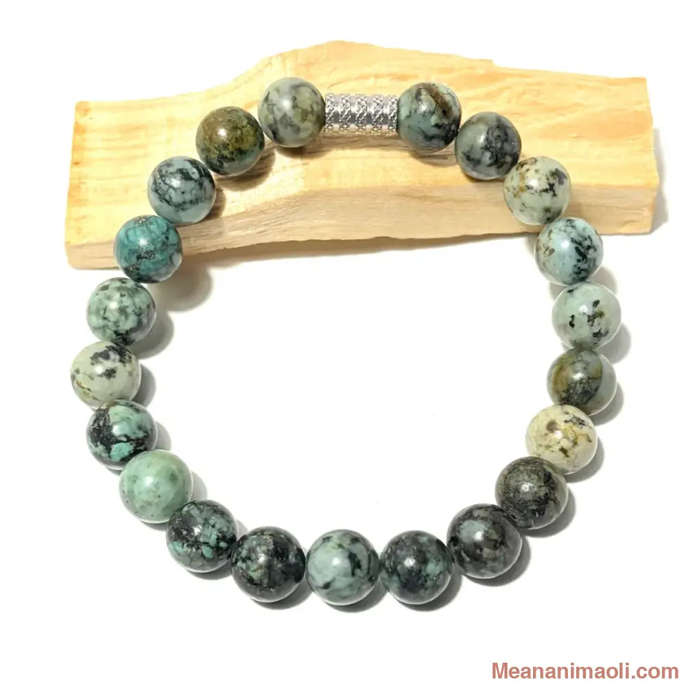 Bracelet en perles de 10 mm Turquoise Africaine naturelle posé sur un bois palo santo