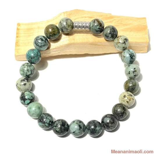 Bracelet en perles de 10 mm Turquoise Africaine naturelle posé sur un bois palo santo