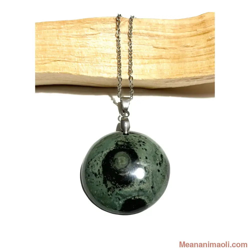 Collier en acier inoxydable avec pendentif Jaspe Kambaba naturel vert et noir posé sur un morceau de bois, meananimaoli