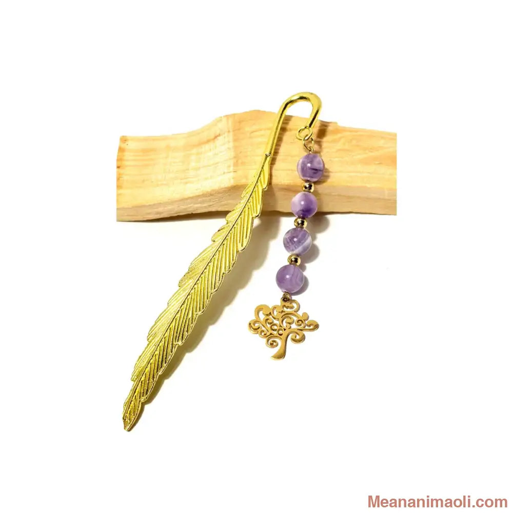 Marque-page en forme de plume dorée avec quatre perles d'Améthyste Chevron violettes et une breloque Arbre de Vie posé sur du bois de Palo Santo - MEANANIMAOLI