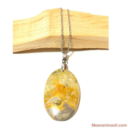 Pendentif ovale en Jaspe Bumblebee naturelle jaune et gris, et collier en acier inoxydable argenté, posé sur bois de Palo Santo, boutique MEANANIMAOLI.