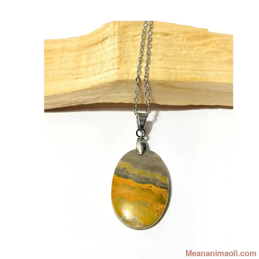 Collier en acier inoxydable avec son pendentif en Jaspe Bumblebee jaune et noir posé sur un morceau de bois Palo Santo, une création MEANANIMAOLI.