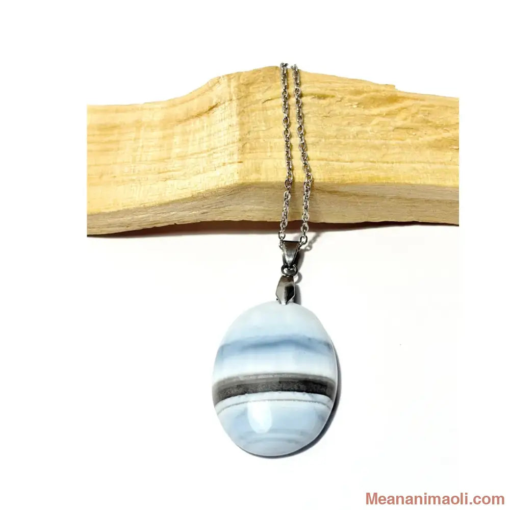 Collier en acier inoxydable avec pendentif Opale Bleue naturelle posé sur un morceau de bois Palo Santo, bijou MEANANIMAOLI.