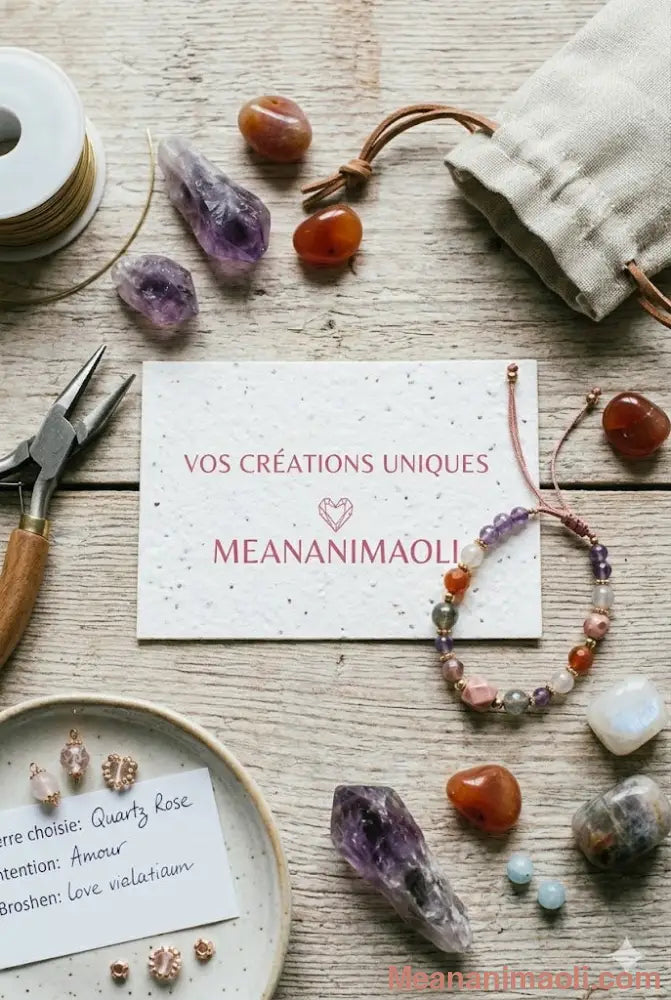 Vue de dessus d'un atelier de lithothérapie pour MEANANIMAOLI : pierres naturelles, bracelet artisanal en perles, outils de création et carte indiquant 'Vos créations uniques